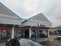 the front of a store with cars parked in front of it